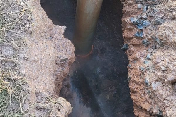 A pipe being uncovered with high pressure water.
