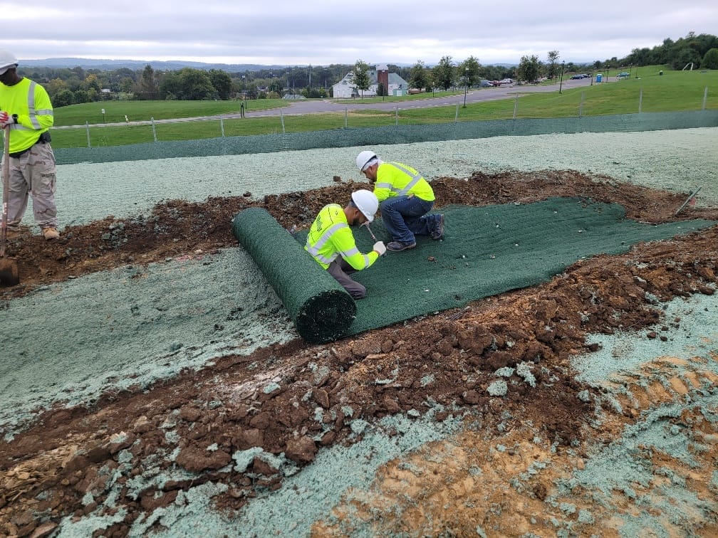 Muller crew members working on an effective erosion control measure laying down erosion blankets on a job site.